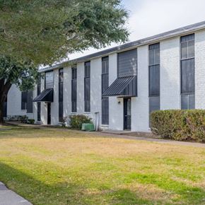 Waco apartment for rent - A white building with black awnings and windows.