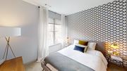 Providence apartment for rent - A bedroom with a large bed and a patterned wallpaper.