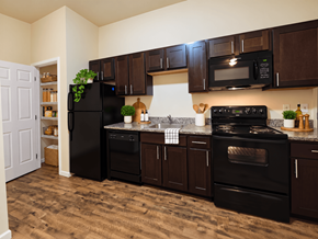 Reading apartment for rent - A kitchen with black appliances and brown cabinets.