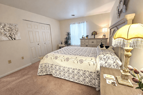 Sinking Spring apartment for rent - A bedroom with a large bed and a dresser with a lamp on it.