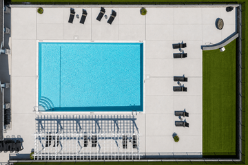 Dover apartment for rent - An aerial view of a swimming pool with lounge chairs and umbrellas.
