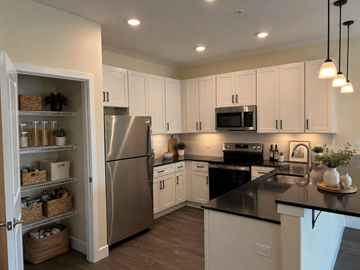 Dover apartment for rent - A kitchen with white cabinets and a black countertop.