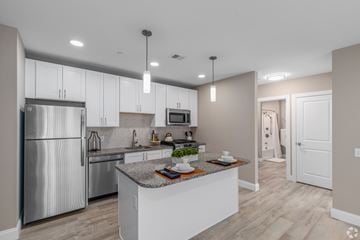 Newark apartment for rent - A modern kitchen with a stainless steel refrigerator and a central island.