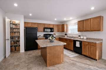 Harrisburg townhouse for rent - A kitchen with a black refrigerator and wooden cabinets.