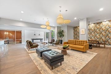 Gaithersburg apartment for rent - A living room with a yellow sofa and a patterned wallpaper on the wall.