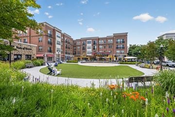 Gaithersburg apartment for rent - A grassy area with flowers in the foreground and a building in the background.