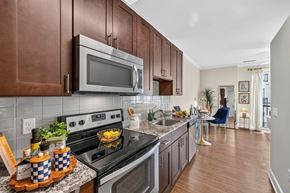 Gaithersburg apartment for rent - A modern kitchen with a stove top oven and microwave.