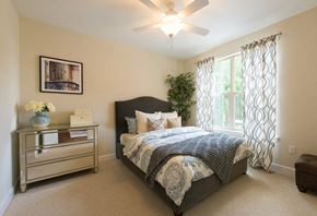 Gaithersburg apartment for rent - A bedroom with a large bed and a ceiling fan.