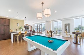 Gaithersburg apartment for rent - A pool table in a room with a kitchen area in the background.