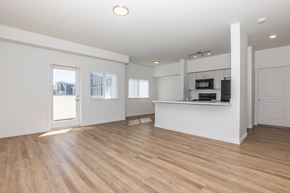 Spanaway apartment for rent - A spacious room with wooden floors and white walls.