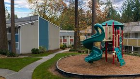 Bellevue apartment for rent - A playground with a green slide and red and white toy.
