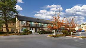 Seatac apartment for rent - A large building with a parking lot in front.