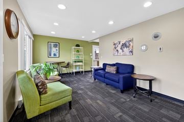 Seatac apartment for rent - A living room with a green chair and a blue couch.