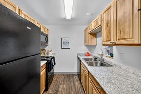 Lynnwood apartment for rent - A kitchen with a black refrigerator and wooden cabinets.