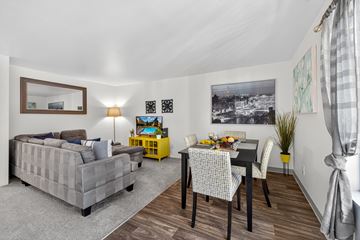 Lynnwood apartment for rent - A grey couch sits in a living room with a dining table and chairs.