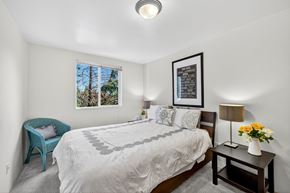 Lynnwood apartment for rent - A bedroom with a large bed and a blue chair.