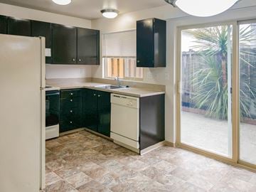 Shoreline apartment for rent - A kitchen with black cabinets and a white refrigerator.