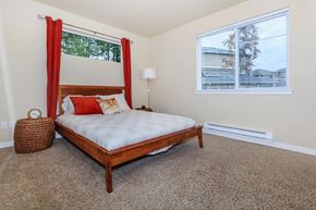 Dupont apartment for rent - A bedroom with a bed, carpet, and a window.