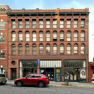 Seattle apartment for rent - A red car is parked in front of a red brick building.