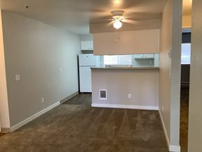Seattle apartment for rent - A kitchen area with a refrigerator, cabinets, and a ceiling fan.