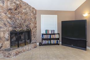 Federal Way apartment for rent - A living room with a stone fireplace and a flat screen TV.