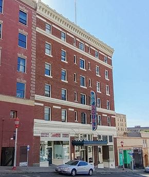 Seattle apartment for rent - A tall red brick building with a sign that says "HOTEL" on the front.