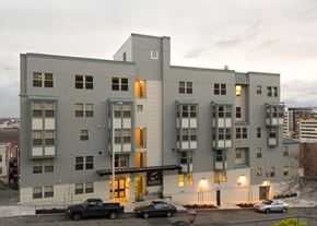 Seattle apartment for rent - A grey building with a black truck parked in front.