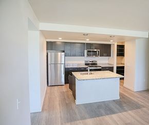 Federal Way apartment for rent - A modern kitchen with a stainless steel refrigerator and a granite countertop.