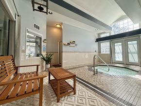 Gig Harbor apartment for rent - A wooden chair and table are placed in a room with a hot tub.