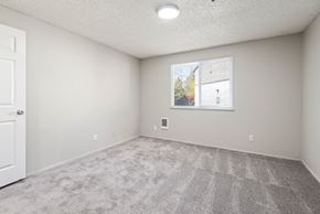 Kent apartment for rent - A room with a carpeted floor and a window showing a view of a house.