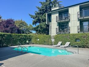 Des Moines apartment for rent - A pool with chairs and a building in the background.