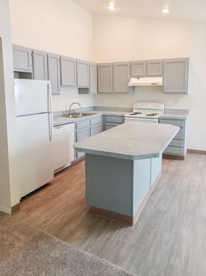 Kent apartment for rent - A kitchen with a white refrigerator and a countertop island.