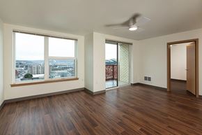 Seattle apartment for rent - A room with a ceiling fan and a view of the city.