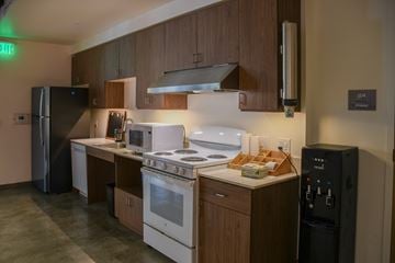 Seattle apartment for rent - A kitchen with a white stove top oven and a black refrigerator.