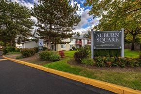 Auburn apartment for rent - A sign for Auburn Square apartments is in front of a building.
