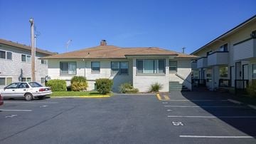 Burien apartment for rent - A parking lot with a car parked in front of a building.
