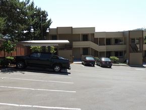 Tukwila apartment for rent - A black truck is parked in a parking lot in front of a building.