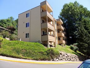 Tukwila apartment for rent - A beige apartment building with a green lawn in front.