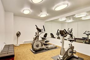 Redmond apartment for rent - A gym with a mirror, a fan, and exercise equipment.