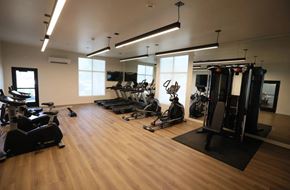 Federal Way apartment for rent - A gym with a variety of equipment including treadmills, stationary bikes, and weight machines.