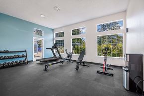 Seattle apartment for rent - A gym with a row of dumbbells on the left and a row of exercise equipment in the middle.