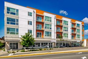Seattle apartment for rent - A modern multi-story building with a white and orange facade.