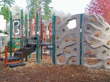 Seattle apartment for rent - A playground with a slide, monkey bars, and a rock climbing wall.
