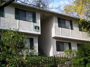 Seattle apartment for rent - A white building with green shutters and a sign on the front.