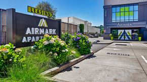 Tukwila apartment for rent - A sign for Airmark Apartments is displayed in front of a building with a leasing sign above it.