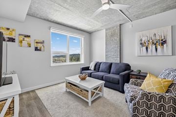 Tukwila apartment for rent - A living room with a grey sofa, a white coffee table, and a painting on the wall.