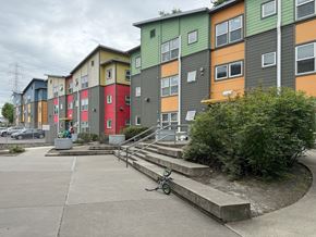 Seattle apartment for rent - A colorful apartment complex with a bicycle parked in front.