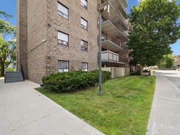 Orillia apartment for rent - A tall brick building with a balcony on the second floor.