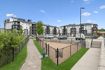 Brantford apartment for rent - A view of apartment buildings with a fenced in playground in the foreground.