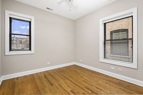Chicago apartment for rent - an empty room with two windows and wood floors